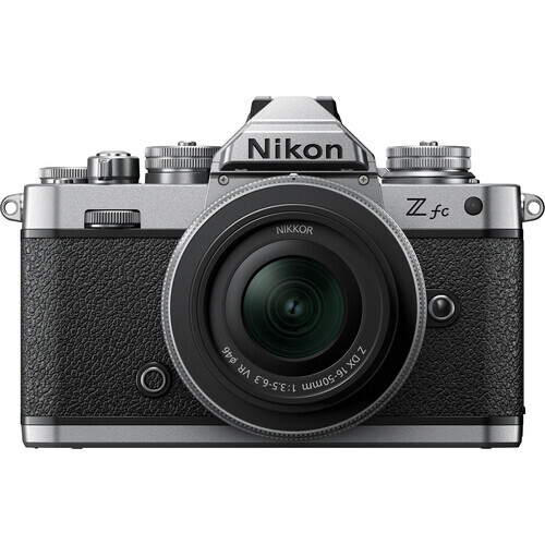 Nikon Z fc mirrorless camera with silver top plate and black body, front view with 28mm kit lens attached.