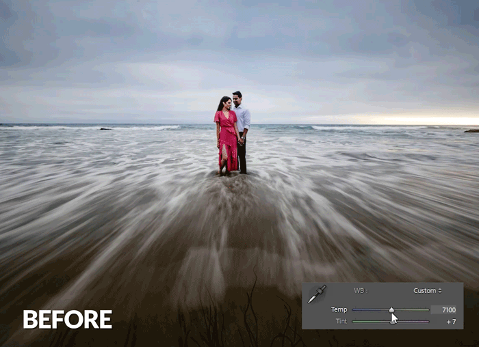 Couple standing in ocean waves with motion blur effect demonstrating before editing state.