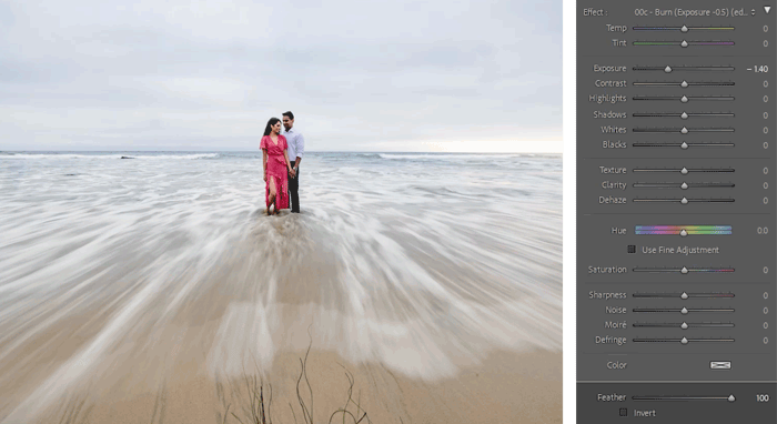 Couple standing in shallow ocean water with flowing wave motion blur in foreground.