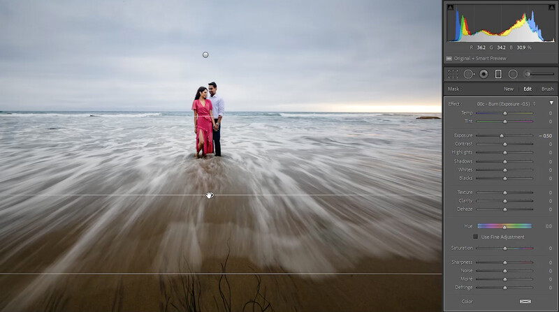 Couple in formal attire standing in shallow ocean water with long exposure motion blur effect.