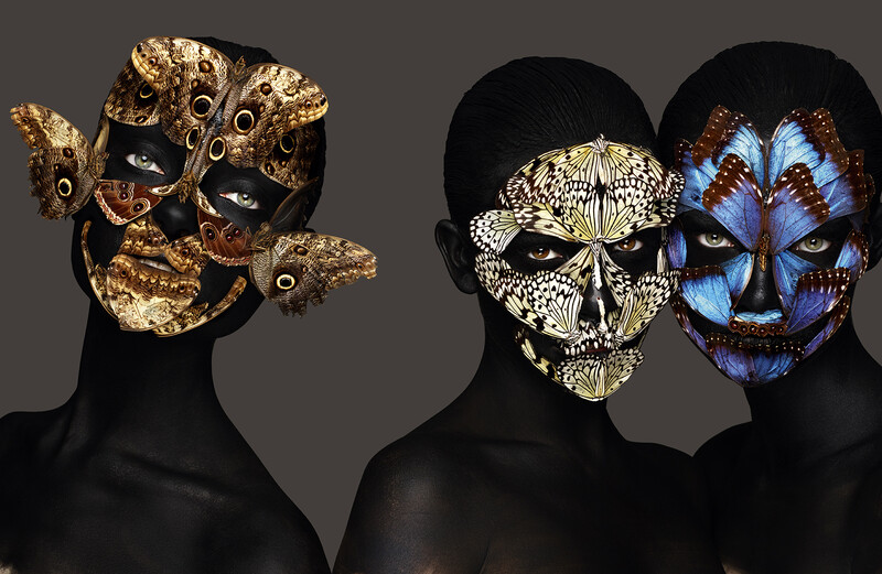 Models with black bodies wearing elaborate gold, shell, and butterfly wing face masks.