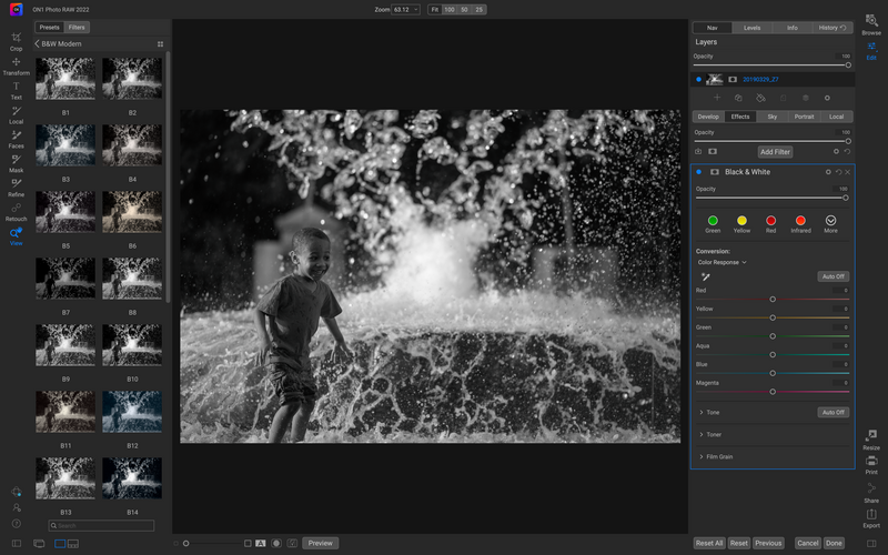 Black and white photograph of a person in water with splashing waves around them.