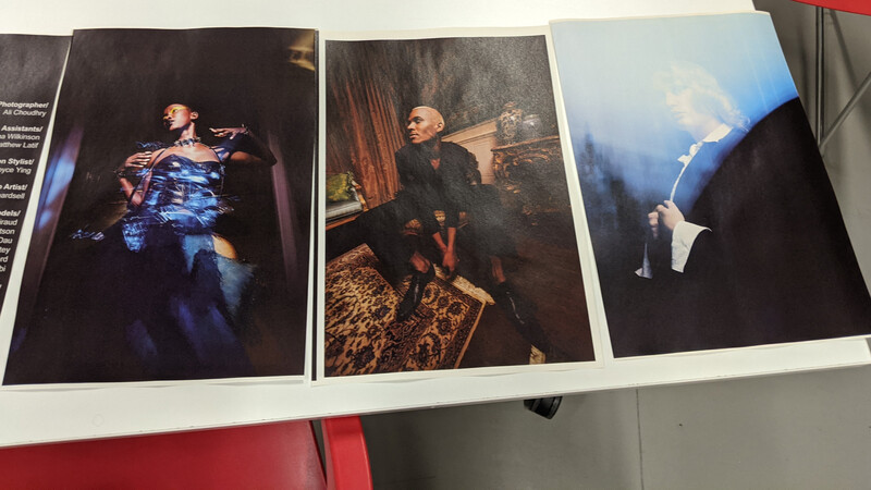 Three printed photographs displayed showing theatrical lighting and performance scenes with dramatic blue and warm tones.