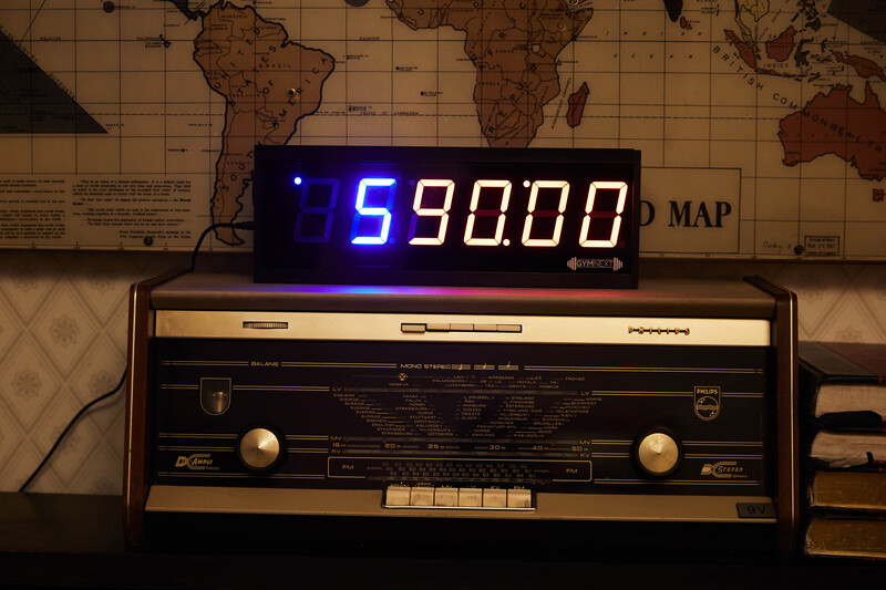 Vintage radio with digital display showing 590.00 against a backdrop of world maps.