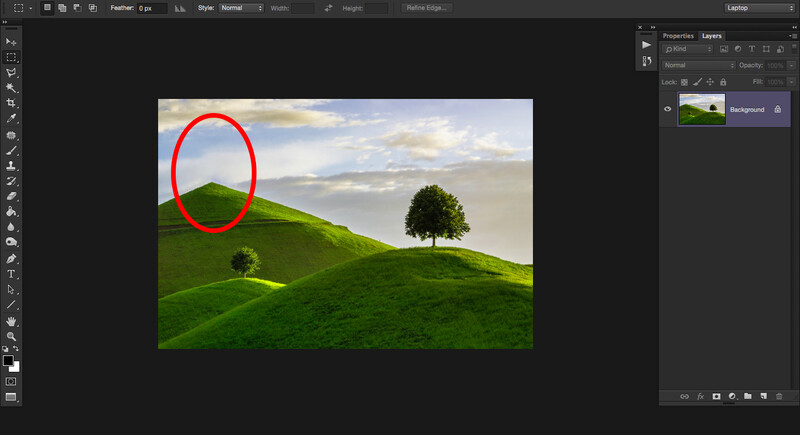 Rolling green hills with a lone tree and red circle marking a hilltop area under dramatic sky.
