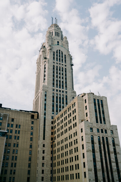 Tall Art Deco skyscraper with cream-colored facade and dark vertical striping, topped with ornamental spires.