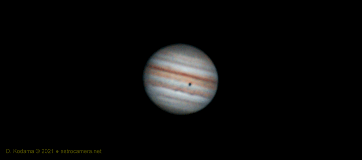 Jupiter photographed through a telescope showing distinctive atmospheric bands and the Great Red Spot.