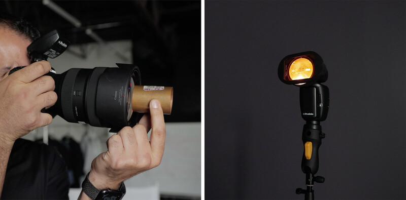 Photographer holding a camera with a telephoto lens next to a studio flash unit with warm gel filter.