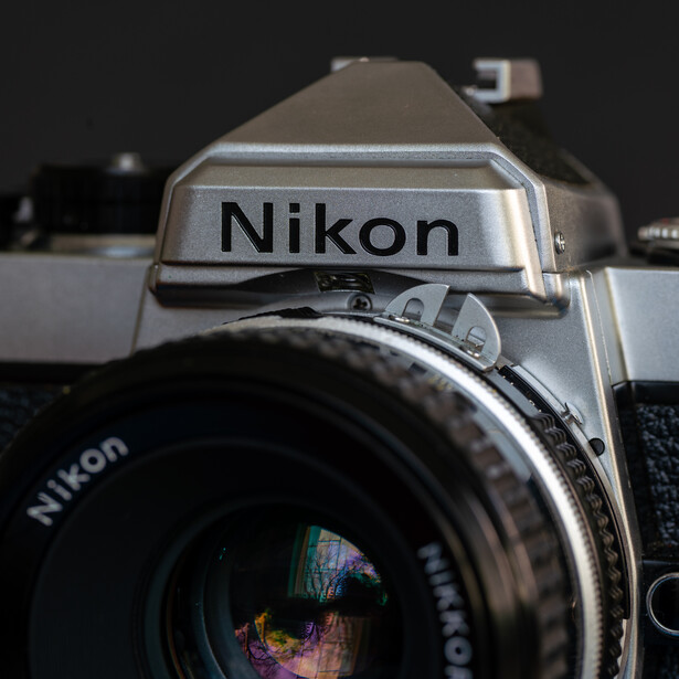 Nikon film camera with standard lens mounted, viewed from above against a dark background.