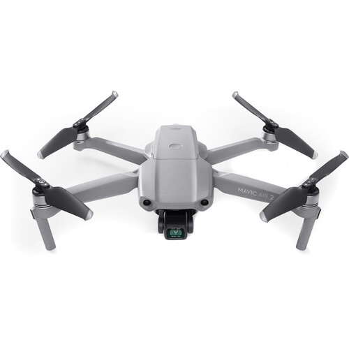 Gray drone with four propellers viewed from above against white background.