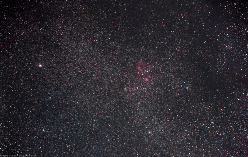 Milky Way galley core stretching across dark night sky with scattered stars and reddish nebula emission.