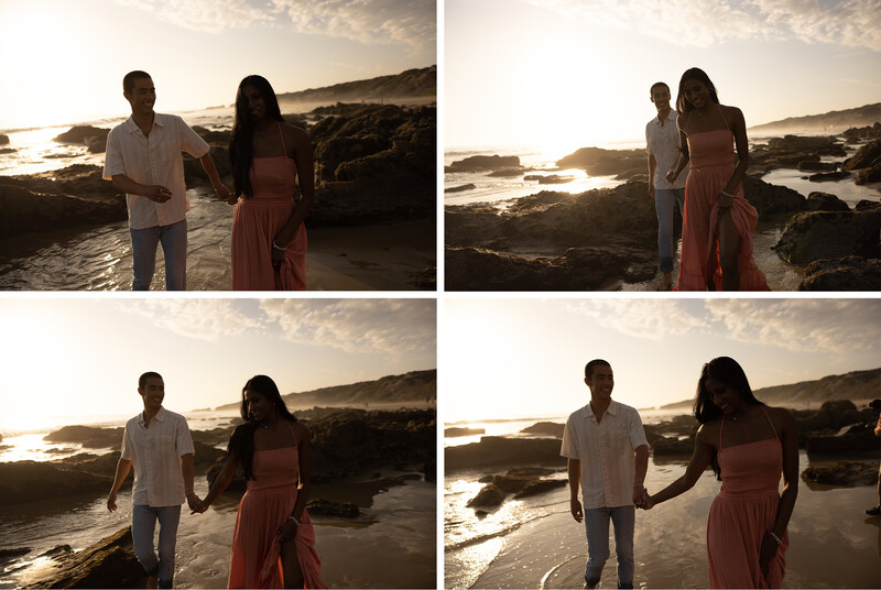 Couple posing together on a rocky beach at golden hour with mountains and ocean in background.