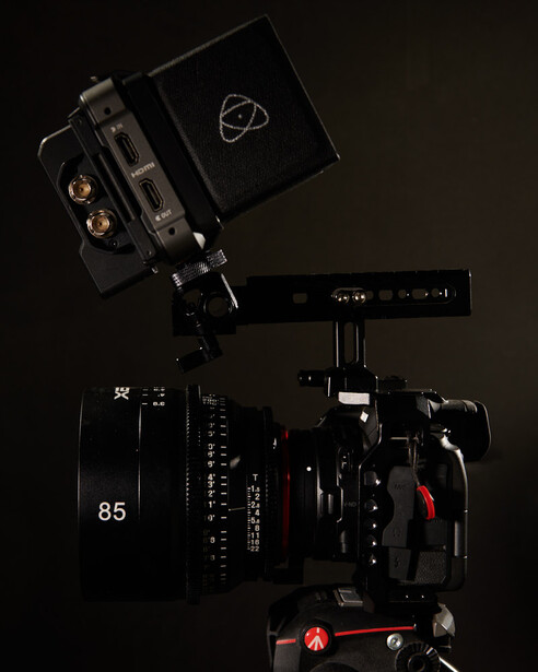 Professional cinema camera rig with matte box, follow focus, and external monitor mounted on support.
