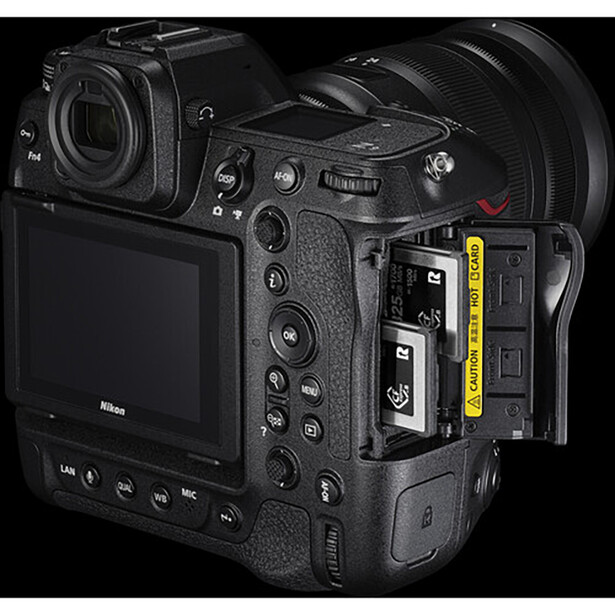 Professional mirrorless camera displayed from rear angle with memory card slot open, showing dual card bays and LCD screen.