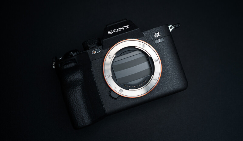 Sony alpha mirrorless camera body with lens mount visible, displayed against dark background.