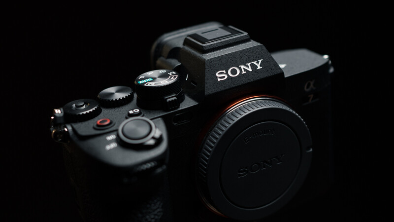 Sony mirrorless camera body displayed against black background with dramatic side lighting.