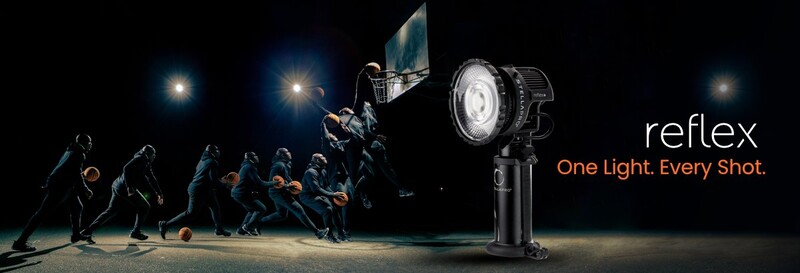 Portable LED light fixture mounted on stand illuminating a nighttime sports scene with players and a flag.