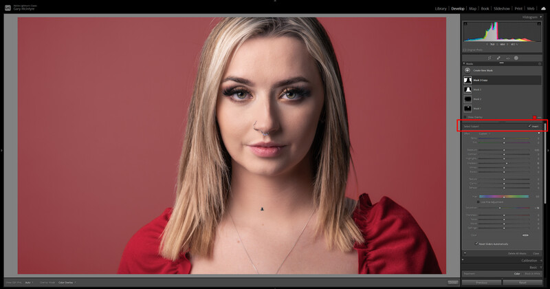 Portrait of a woman with long blonde hair wearing a red top against a pink background.