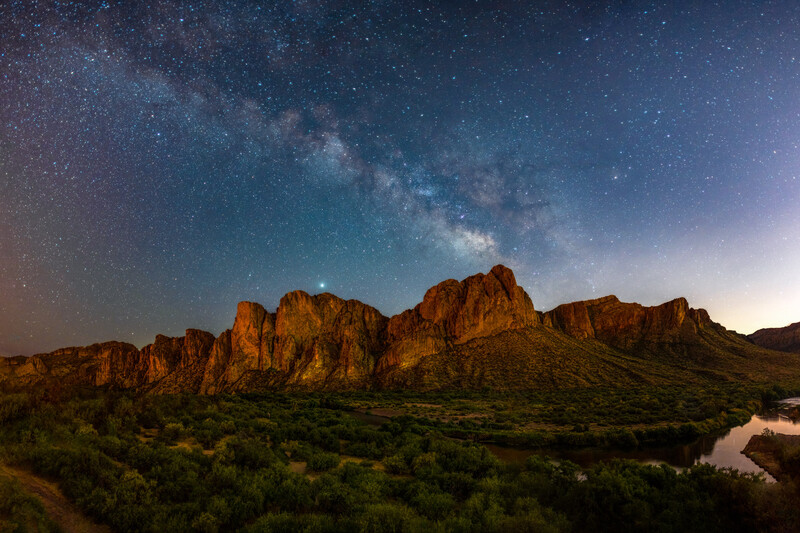 Rugged desert mountains beneath the Milky Way galaxy at night.