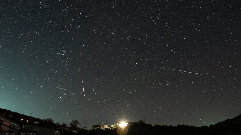 Night sky photograph with multiple meteors streaking across stars above a moonlit landscape.