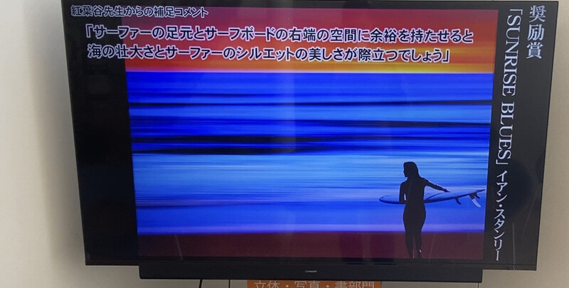 Screenshot of instructional surfing video with silhouetted surfer holding board against blue ocean backdrop.