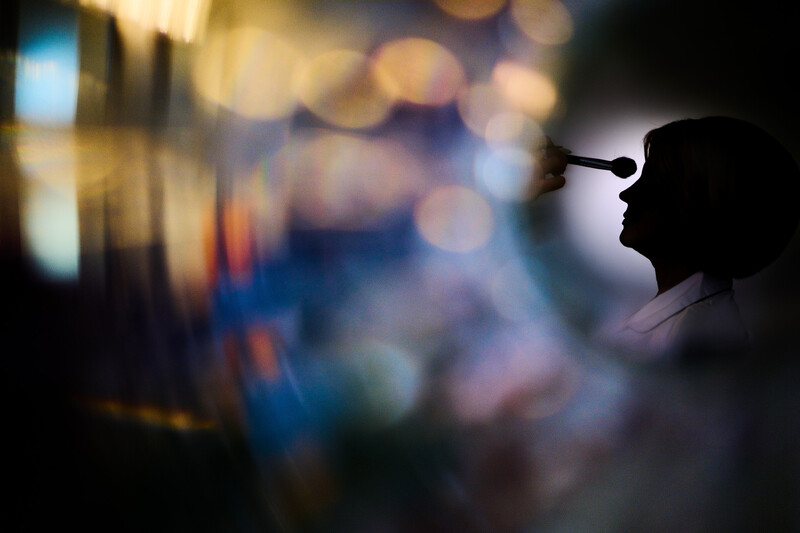 Silhouetted profile of a person looking toward a blurred urban scene with warm and cool bokeh lights.