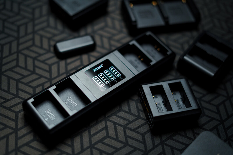 Modular camera flash units with control panel and accessories arranged on patterned surface.