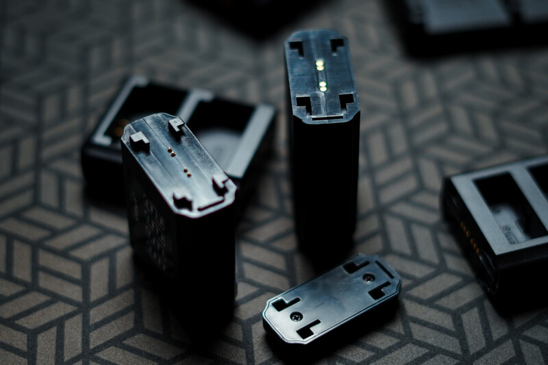 Disassembled smartphone components arranged on a patterned surface, showing interior metal frames and connector ports.