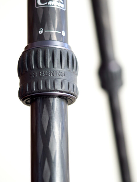 Close-up of a camera lens with focus ring and depth-of-field scale markings.
