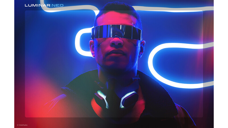 Person wearing futuristic visor and headphones surrounded by neon blue and pink lighting tubes.