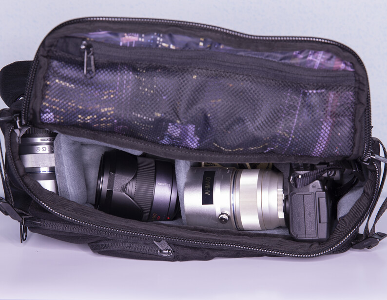The bag works better with smaller DSLR and mirrorless cameras. I was able to fit a Micro Four Thirds body (Panasonic G85) and two extra lenses for a day of shooting. There's still room for a small prime or other accessories in there as well, though the ba