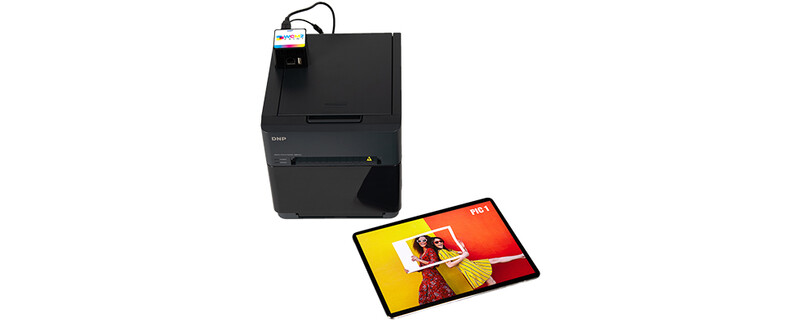 Thermal label printer positioned above a color sample card displaying yellow and red tones.