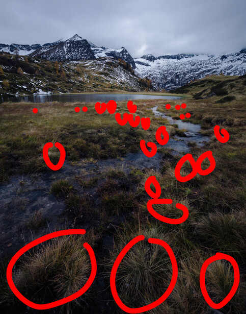 Alpine valley landscape with snow-capped mountains overlaid with red smiley faces and zeros.