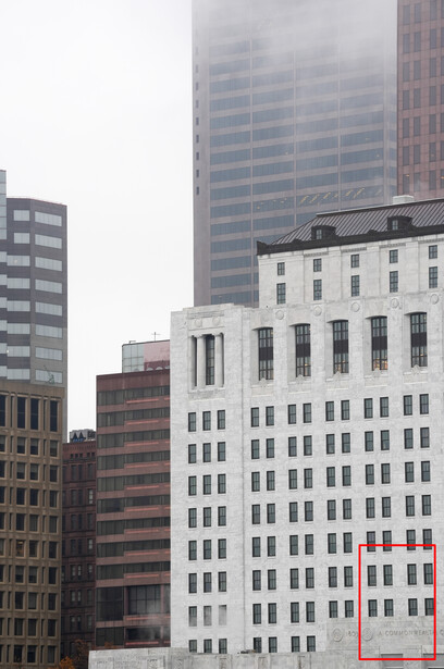 Urban skyline with mix of historic and modern buildings under overcast sky.