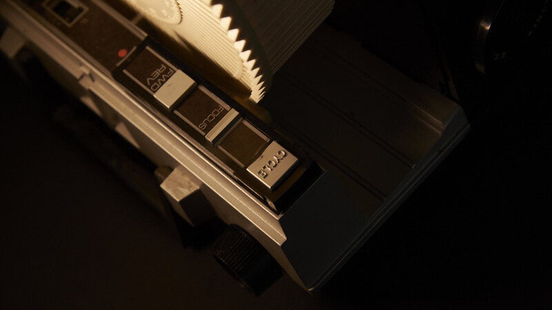 Top-down view of a keyboard synthesizer with illuminated keys and control panel against dark background.