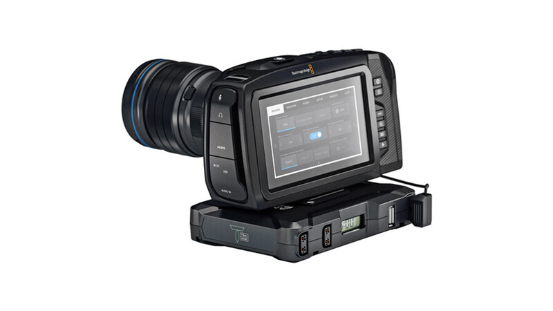 Professional cinema camera with attached lens and external monitor mounted on base unit.