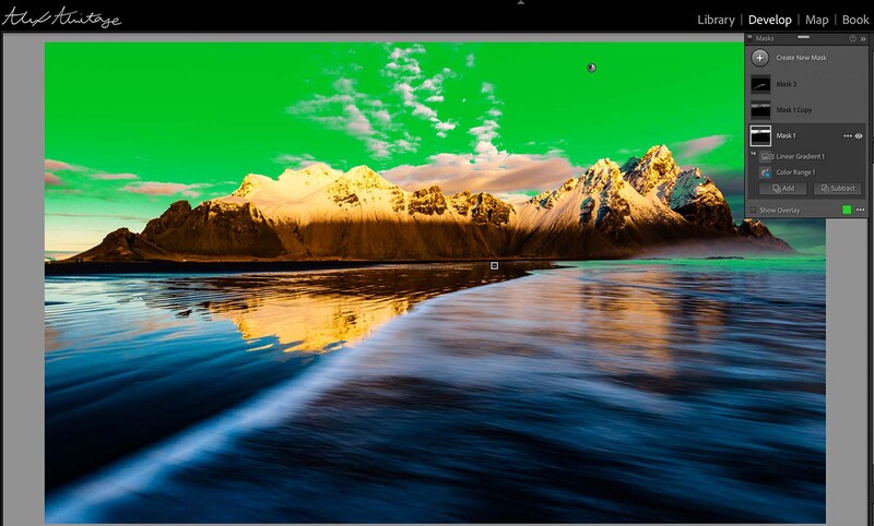 Screenshot of photo editing software showing a coastal landscape with vibrant green sky and golden-lit mountains reflected in blue water.