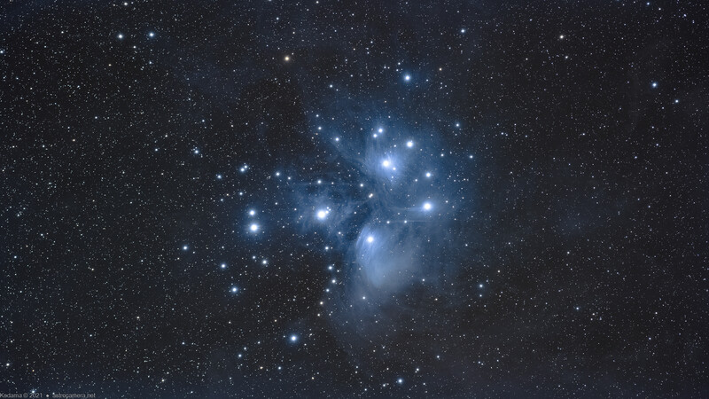 The Pleiades star cluster glows with blue nebulosity against a starfield.