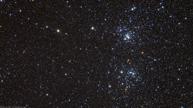 Two star clusters with blue and white stars against a dense field of distant stars on a black sky.