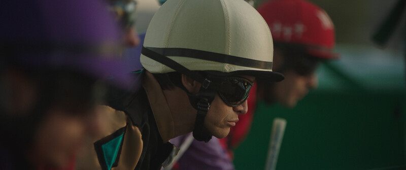 Person wearing a white helmet and dark sunglasses with shallow depth of field background.