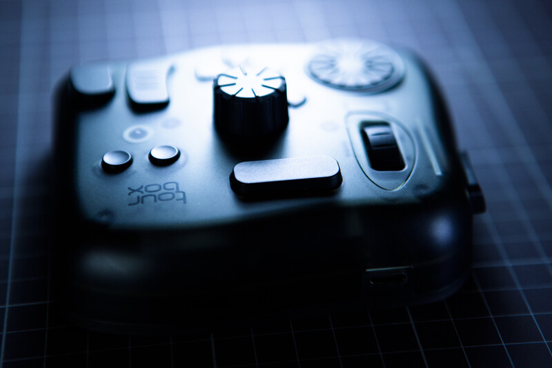 Close-up of a game controller with blue-toned lighting and shallow depth of field.