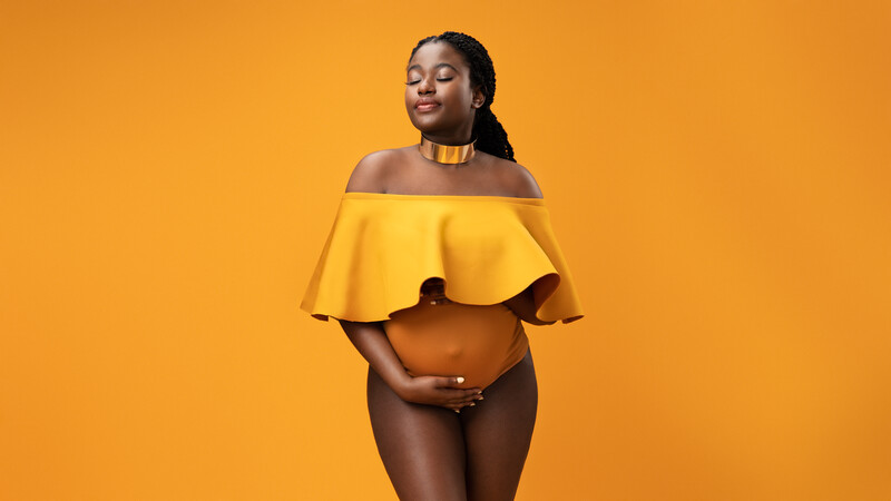 Woman in yellow off-shoulder ruffle top against solid yellow background.