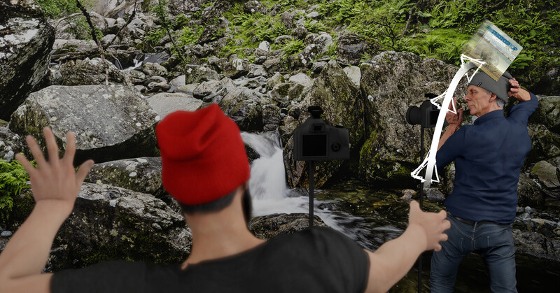 Photographer holding a light reflector while another person adjusts camera settings near a flowing stream surrounded by moss-covered rocks.