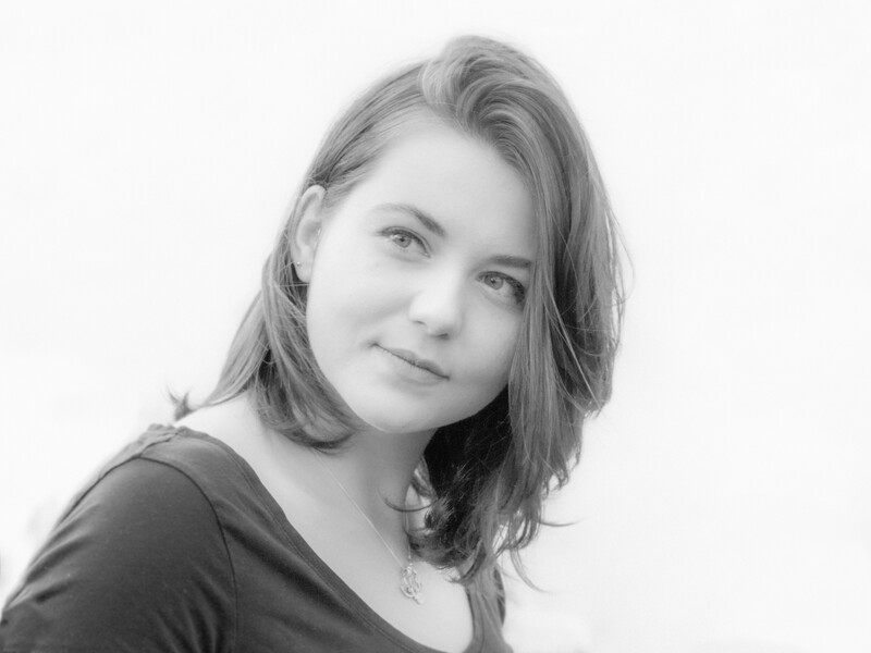 Black and white portrait of a young woman with shoulder-length hair gazing toward the camera.