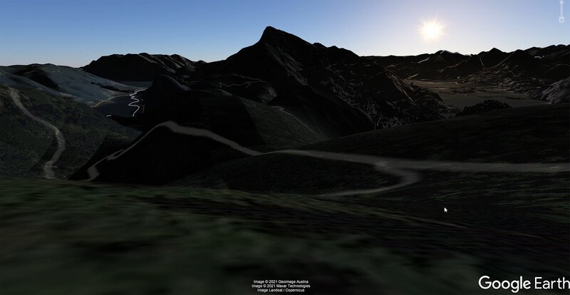 Dramatic volcanic landscape with dark lava fields and jagged peaks under bright sunlight.