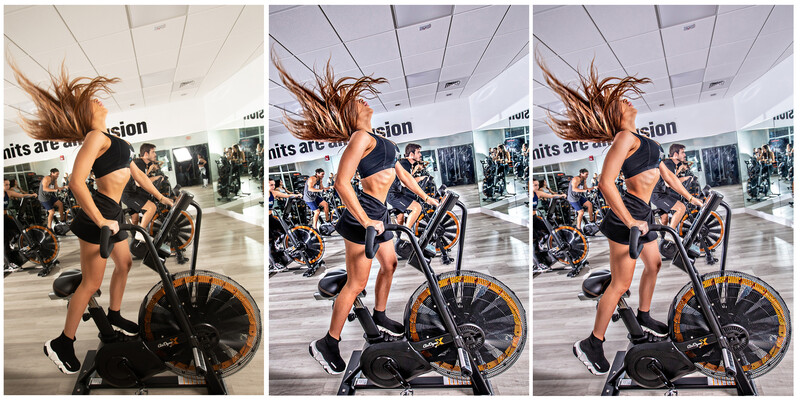 Woman on stationary exercise bike with hair in motion against indoor gym backdrop.