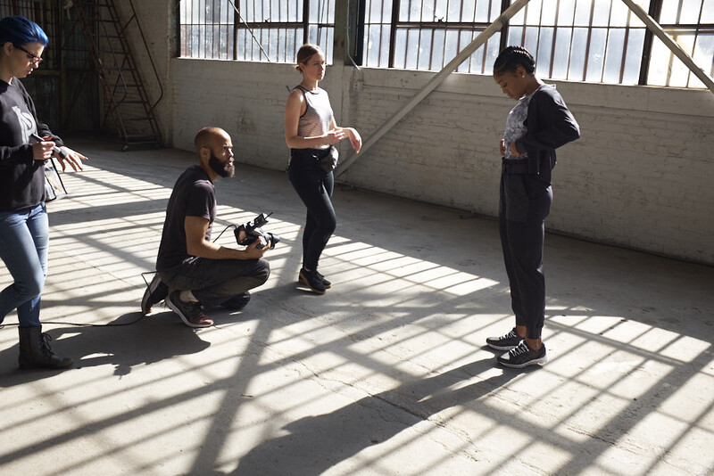 Group of people gathered in a concrete space during a photography workshop or training session.