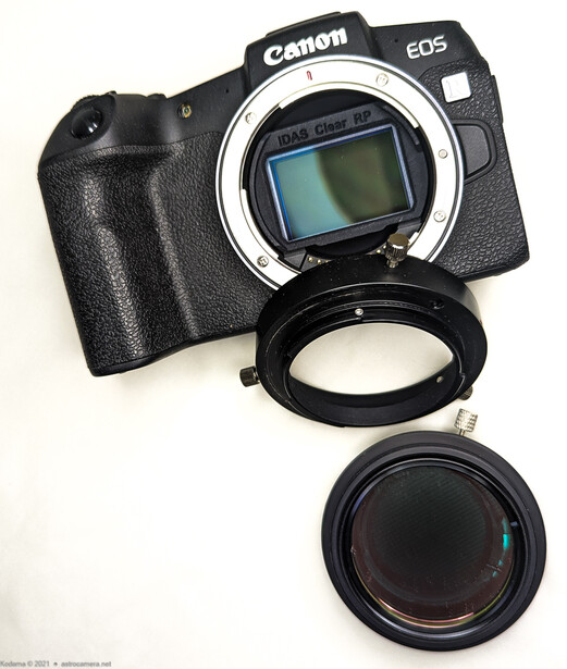 Canon EOS camera body with detached lens and lens adapter ring displayed on white background.