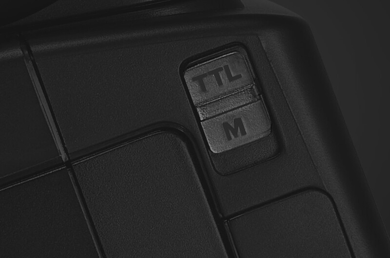 Close-up of camera buttons showing TTL and M mode selector on black camera body.