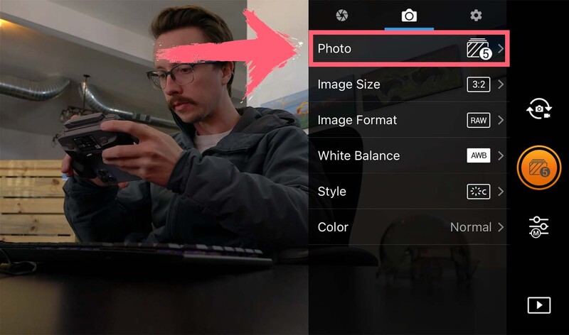 Photographer adjusting camera settings using a mobile app interface with editing controls displayed.